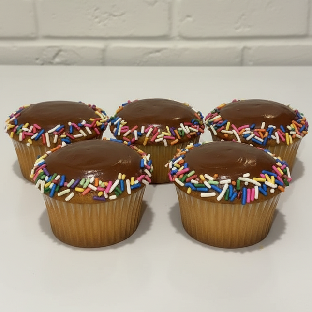 6 vanilla cupcakes with chocolate hard icing